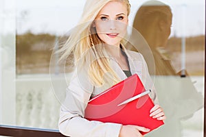 Young manager girl with a red folder and books