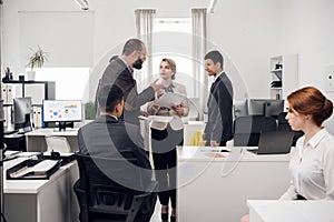 A young Manager gives paper documents to the head of the HR Department in the office of the leasing company for