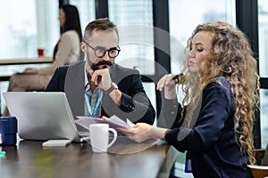 Young manager listening to his colleague explanations in modern co working office