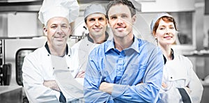 Young manager posing with some chefs