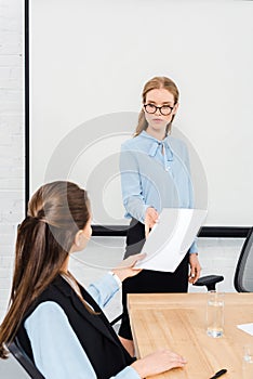 young manageresses passing documents