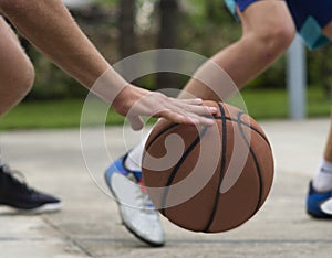 Young mans on basketball court dribbling with ball. Streetball, training, activity