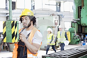 Young manual worker operating machinery in metal industry