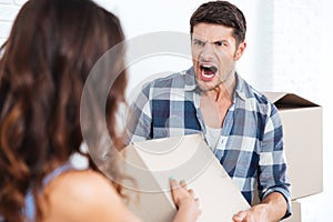 Young married couple arguing during relocation
