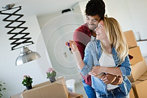 Young married couple with boxes and holding flat keys