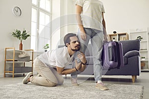 Young married couple breaking up and angry wife leaving home with packed suitcase