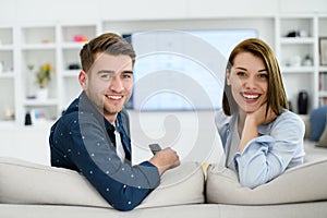 a young married couple enjoys sitting in the large living room