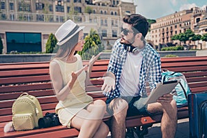 Young married couple got lost on vacation in town. Frustrated lady is arguing with her boyfriend, who holds pda, has no idea where