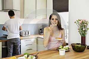 A young married couple having breakfast at home