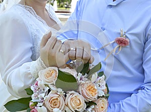 Young married couple holding hands, ceremony on their wedding day