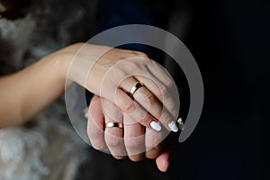 Young married couple holding hands, ceremony wedding day.