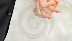 Young married couple holding hands, ceremony wedding day