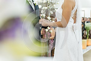 Young married couple holding hands, ceremony wedding day