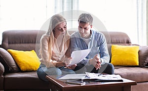 Young married couple looking through tenancy agreement in house for sale photo