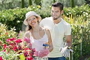 Young married couple seedling garden plants