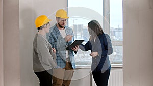 Young married couple signing papers for the apartment rental with a real estate agent