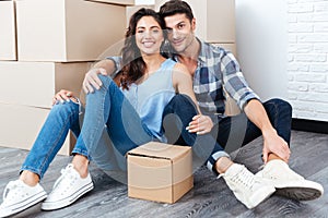 Young married couple sitting in their new house