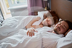 Young married couple sleep together, lie on bed