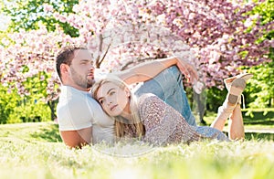 Young married people in love enjoying the spring beautiful nature. Beautiful young couple enjoying flowering garden. Man