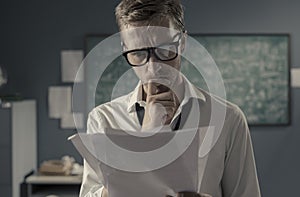 Young mathematician studying in his office and reading papers