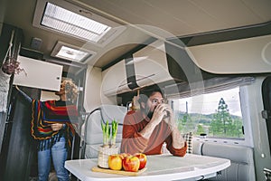Young mature couple of tourist enjoying camper van adventure lifestyle together inside in leisure activity. Man and woman in