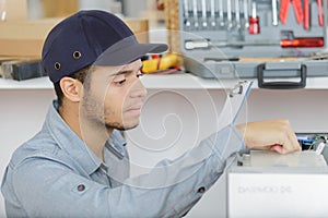 young mechanic apprentice working fixing machine