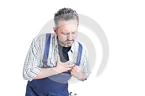 Young mechanic having pain in his chest and palpitation photo