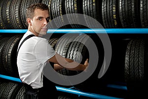 Young Mechanic holding a car tire