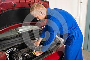 Young Mechanic Repairing Car