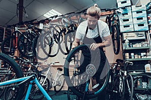 Young Mechanic Repairs Bicycle in Bike Workshop