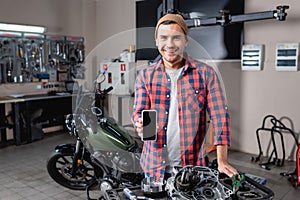 young mechanic in workwear making diagnostics