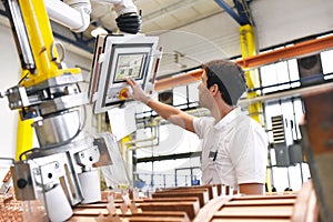 young mechanical engineering workers operate a machine for winding copper wire - manufacture of transformers in a factory photo