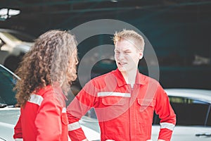 Young mechanics team in uniform are working in a repair garage. Car repair and maintenance concepts