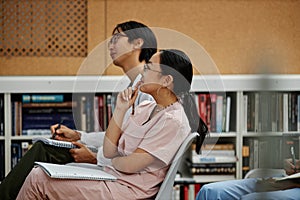 Young med students sitting in row in audience during lecture or seminar