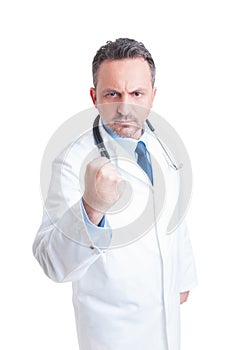 Young medic or doctor showing fist and threatening