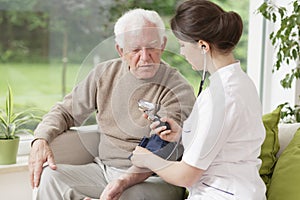 Young medic taking blood pressure