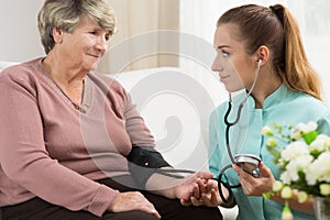 Young medic taking blood pressure