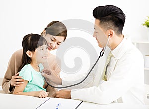 Young medical doctor examining a little girl in office