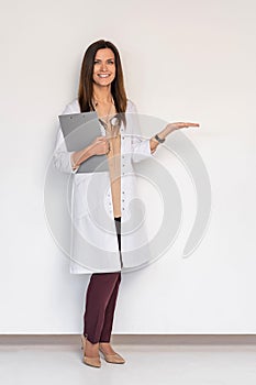 Young medical doctor woman presenting and showing copy space for product or text. Caucasian female medical professional