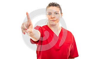 Young medical nurse wearing red scrub showing denying gesture photo