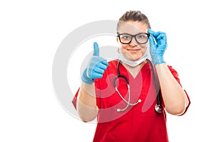 Young medical nurse wearing red scrub showing thumb up gesture