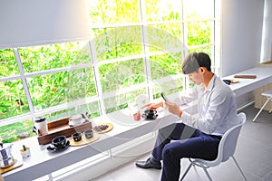 Young men eat coffee and take a photograph of beautiful fish