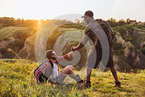 Young men, friends walking, strolling together outskirts of city, at summer forest. Active lifestyle, travel, support