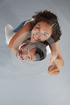 Young man holding woman showing thumb up