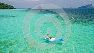 Young men in a kayak at the bleu turqouse colored ocean of Koh Kradan Thailand