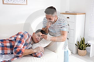 Young man with marker near sleeping friend. April fool`s day photo