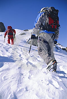 Young men mountain climbing on snowy peak