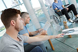 Young men and one in wheelchair in waiting room