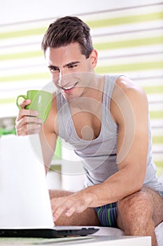 Young men in pajama using laptop