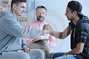 Young men reconciled during therapy with counselor for rebellious teenagers